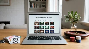 Laptop showing a casino game catalogue beside playing cards and neutral gaming tokens